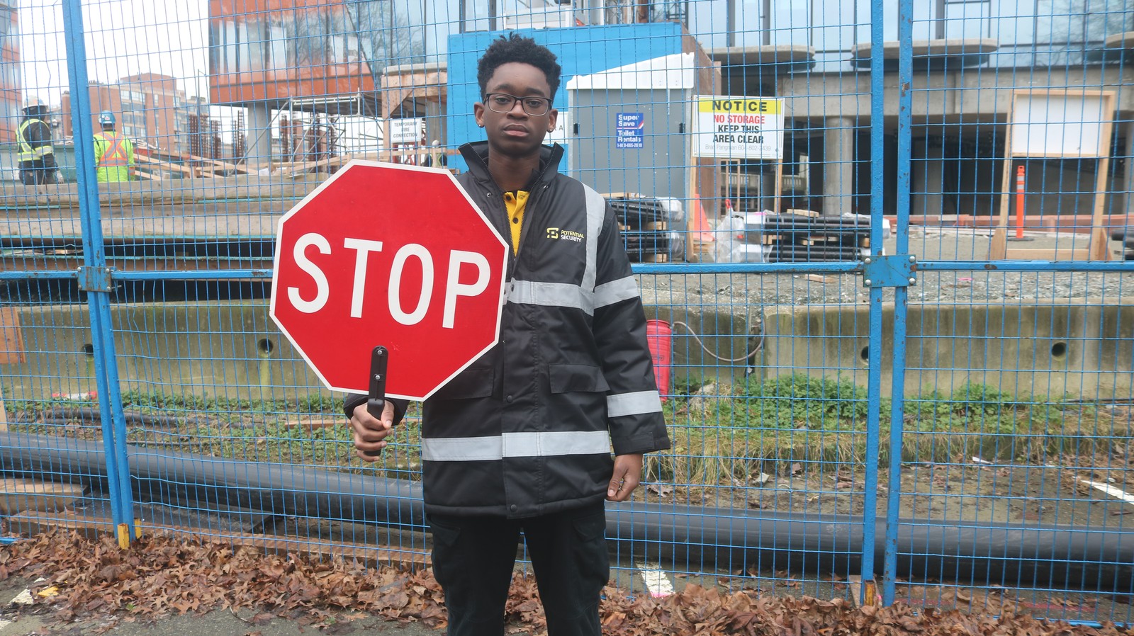 security-guard-holding-stop-sign-at-construction-site | GPS: 49.264367, -122.743249