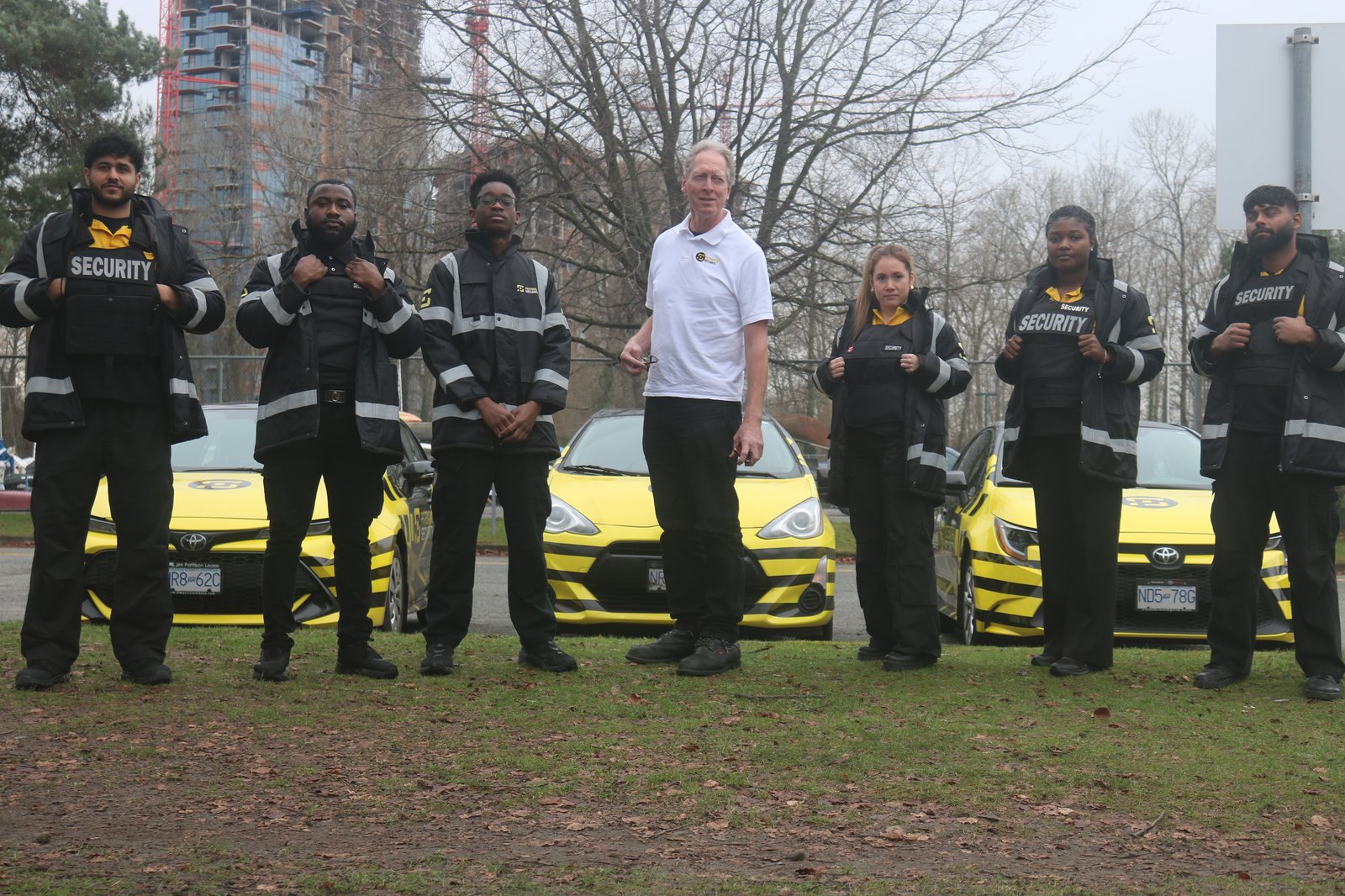 security team poses with yellow vehicles in langley park Traffic Control Services Designed for Surrey